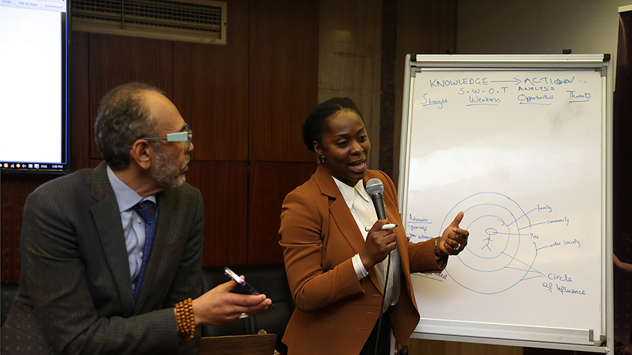 A presenter gestures to a diagram at the pilot training in Alexandria